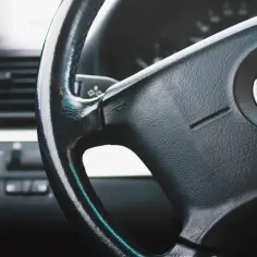Kierownica BMW z widocznym logo i elementami deski rozdzielczej.