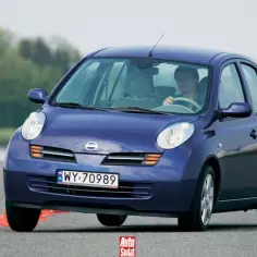 Niebieski Nissan Micra K12 na torze z pachołkami. Kierowca ćwiczy manewry.