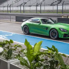 Zielony Mercedes-AMG GTR na torze wyścigowym, gotowy do startu.