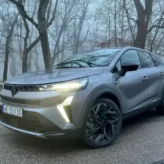 Szary Renault Symbioz na tle mglistego lasu. Jego wymiary sugerują kompaktowe, ale przestronne wnętrze.