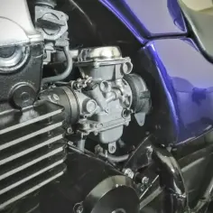 Silnik motocykla z fioletowym bakiem i gaźnikiem. Gotowy do dolotu i dalszej jazdy.