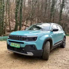 Turkusowy Jeep Avenger na tle lasu. Sprawdź jego kompaktowe jeep avenger wymiary, idealne do miejskich dżungli i leśnych ścieżek.