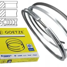 Zestaw tłoków Goetze w żółtym opakowaniu. Widoczne przekroje pierścieni i same pierścienie.