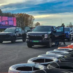 Kolejne modele Maxus pickup gotowe do jazdy na torze. Czarne, niebieskie i czerwone auta czekają na kierowców.