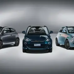 Trzy stylowe samochody fiat elektryczny w różnych kolorach: szary, granatowy i błękitny, prezentują nowoczesny design.