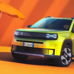 Nowy, zielony Fiat Panda Grande gotowy na wakacje. Obok leżak, parasol i dmuchany flaming.