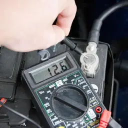 Pomiar napięcia akumulatora multimetrem pokazuje 12.6V.