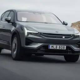 Szary Polestar 3 pędzi po pustynnej drodze, jego światła LED oświetlają horyzont.