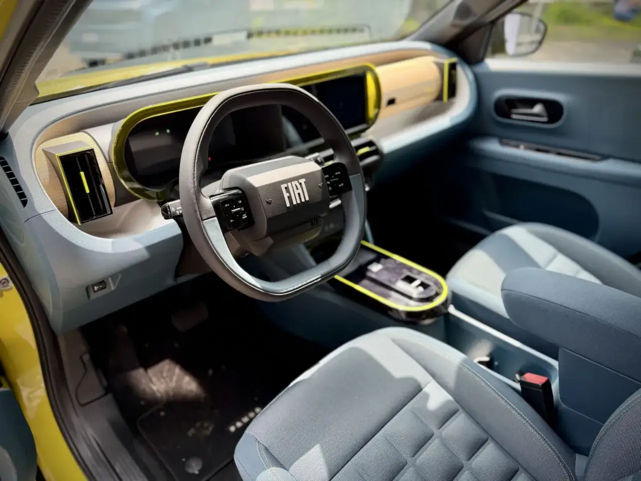Wnętrze nowego Fiat Panda Grande. Jasne, nowoczesne, z żółtymi akcentami i dużym ekranem.