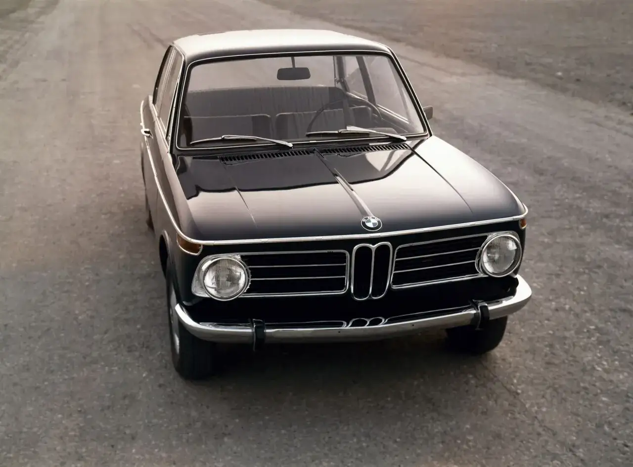 Klasyczny, czarny BMW 2002 stoi na pustej drodze, gotowy na kolejną podróż.
