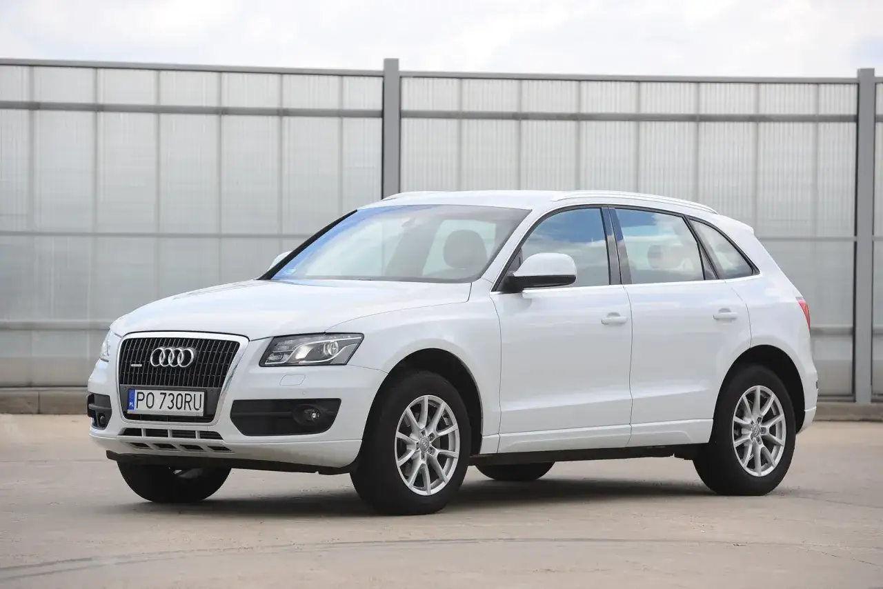 Białe Audi Q5 na tle nowoczesnej ściany. Sprawdź audi q5 wymiary, by poznać jego gabaryty.
