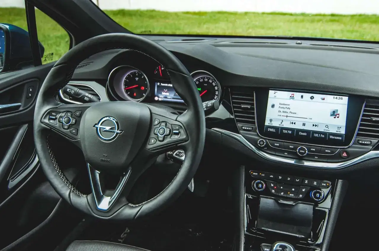 Wnętrze Opla Astry Turbo z multimedialnym ekranem i kierownicą.
