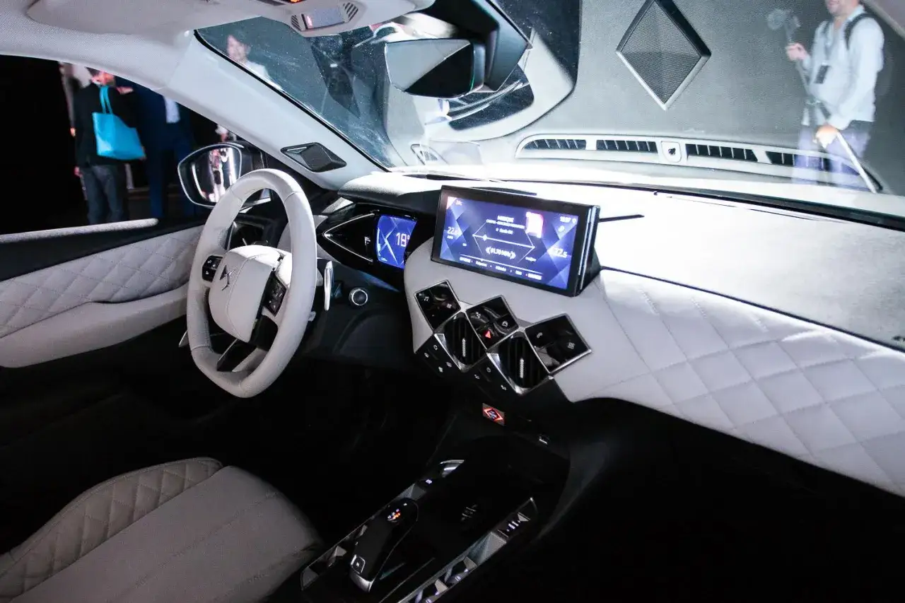 Wnętrze DS3 Crossback z białym, pikowanym wykończeniem, nowoczesną kierownicą i ekranem multimedialnym.