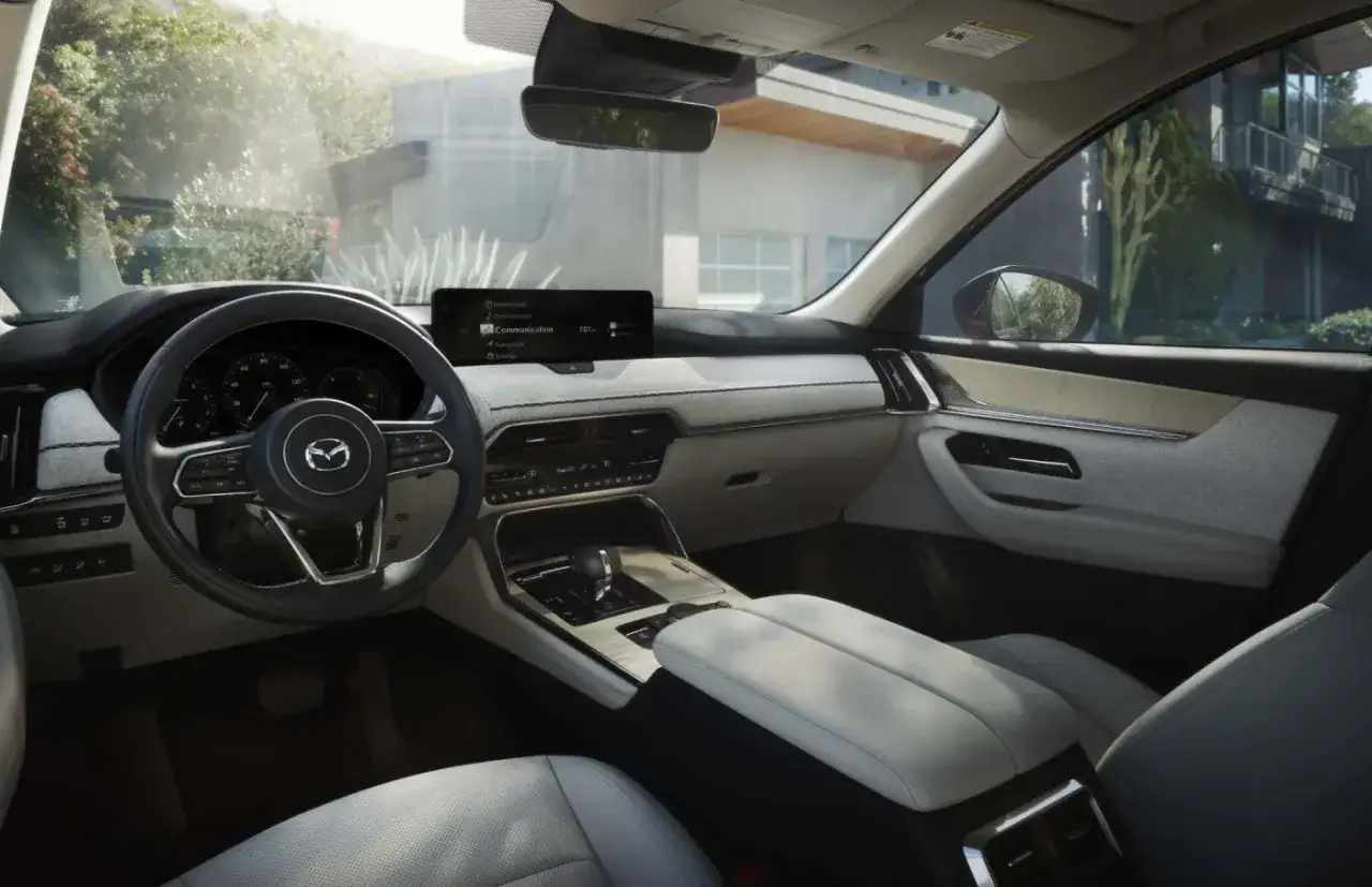 Wnętrze Mazdy CX-90: skórzana tapicerka, nowoczesny ekran multimedialny i eleganckie detale.