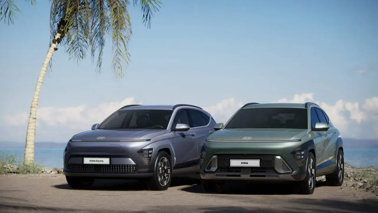 Dwa nowe Hyundai Kona, jeden elektryczny, stoją na tle plaży. Sprawdź aktualną hyundai kona cena i wybierz swój wymarzony model.