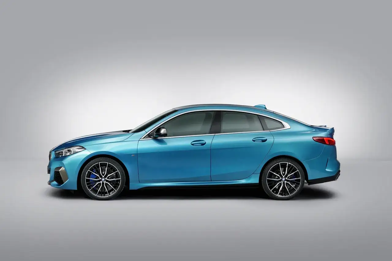 Błękitne BMW Gran Coupe z przyciemnianymi szybami i sportowymi felgami prezentuje się dynamicznie na szarym tle.