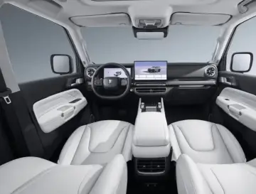 Wnętrze luksusowego SUV-a z białymi skórzanymi fotelami i nowoczesnym ekranem. Sprawdź atrakcyjną tank 300 cena!