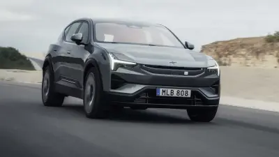 Szary Polestar 3 pędzi po pustynnej drodze, jego światła LED oświetlają horyzont.